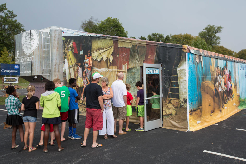 People line up to enter the tent for The Compassion Experience.